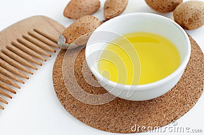 Small bowl with almond oil and wooden hair comb for natural hair Stock Photo