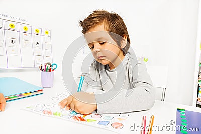 Small boy draws with pencil on the paper sitting Stock Photo