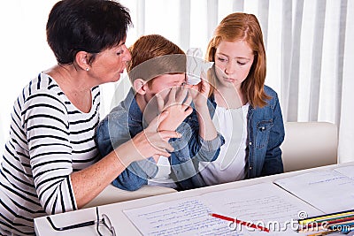 Small boy gets comforted by mother and sister Stock Photo