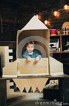 Small boy play in paper rocket, childhood. Earth day concept. Education and kid idea development. Travel and adventure Stock Photo