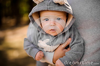 Small boy with pensive gray eyes looks attentively sitting at the fathers hands Stock Photo
