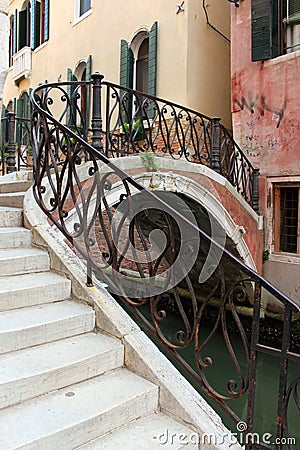 Small bridge over the canal in Venice. Iron handrail. Stock Photo