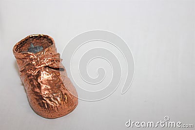 Small bronze baby shoe for an invitation Stock Photo