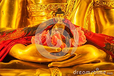 Small Buddha Sakyamuni statue in hands of large Stock Photo