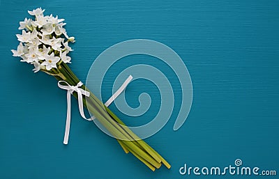White narcissi, tied with ribbon on a blue background Stock Photo