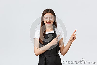 Small business, employees and coffee shop concept. Cheerful smiling pretty waitress showing way. Cute saleswoman in Stock Photo