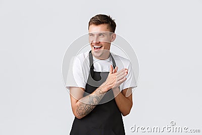 Small business owners, coffee shop and staff concept. Devious and smart funny barista in black apron, cafe worker Stock Photo