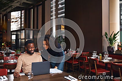 Small business owners using laptop in restaurant Stock Photo