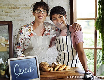 Small business partnership women friends at bakery shop smiling Stock Photo