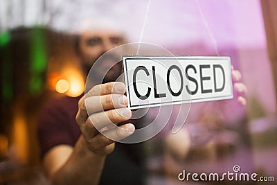 Owner puts closed sign at bar or restaurant window Stock Photo