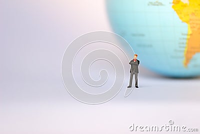 Small businessman figures standing on turning point on earth background. Stock Photo