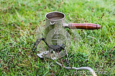 Small camping gas stove and small coffee cezve in the morning Stock Photo