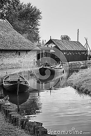 Small canal with its traditional fishing boats, fish smoker in the background Stock Photo