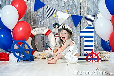 The small captain sits on the floor in a marine style. We mark the first year. Stock Photo