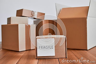 Small cardboard box with fragile label on wooden desk Stock Photo