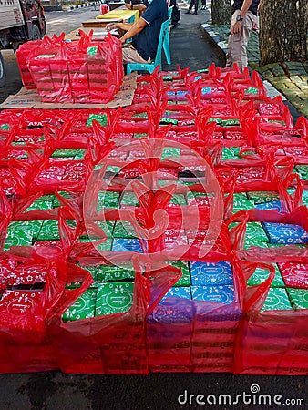 small cardboard filled with snacks in a red plastic bag Editorial Stock Photo