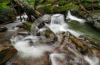 Small cascade on the river among bouders in forest Stock Photo