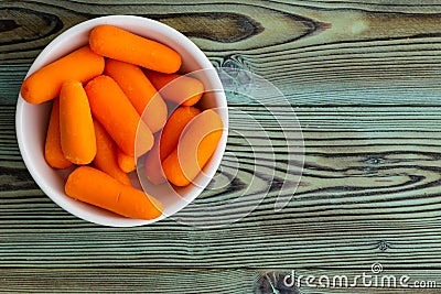Small ceramic bowl of fresh baby carrots Stock Photo