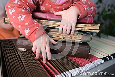 Small child, baby, girl hold a stack of old photo albums on an archival metal cabinet with thin files, home archive, concept of Stock Photo