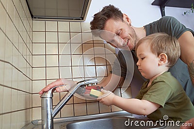 Small child with interest helps man around house Stock Photo