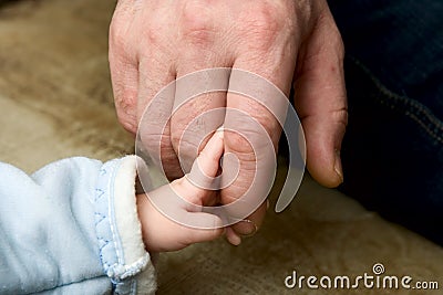 The small child keeping for a finger of the father Stock Photo