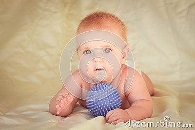 Small child lying on his stomach near the ball for massage. Stock Photo