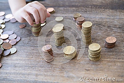 small child manipulate with metal coins, kid counts, puts euro union money on table, finance literacy development, concept pocket Stock Photo