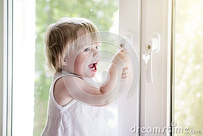 Small child near window. lock on handle of window. Child`s safet Stock Photo