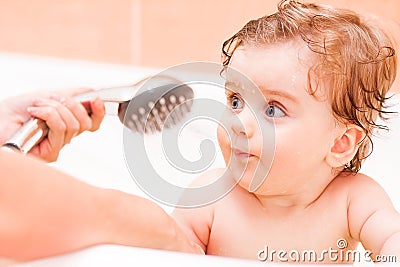 Small child pour out of the shower in the bathroom. Stock Photo