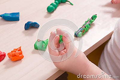 A small child sculpts from plasticine, a wooden light table Stock Photo