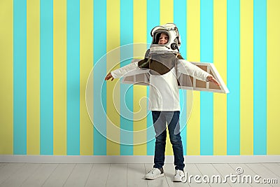 A Small child wants to fly an airplane wearing an airplane helmet Stock Photo