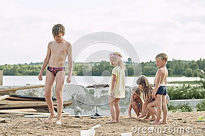 Small children play in the sand in the yard of their house in the summer. Stock Photo