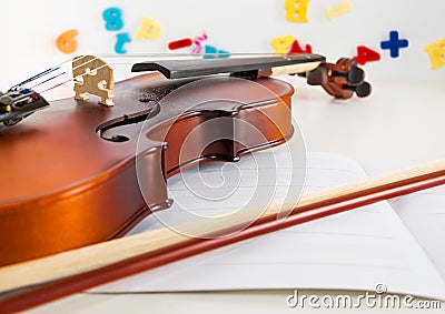 A Small Children`s Violin and Bow on a Child`s Study Desk Stock Photo