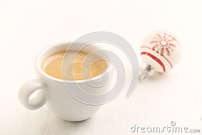 Small Christmas bauble and a cup of coffee. Stock Photo