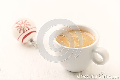 Small Christmas bauble and a cup of coffee. Stock Photo