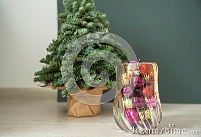 Small Christmas tree near the wall, in a vase Christmas toys for decorating the tree Stock Photo