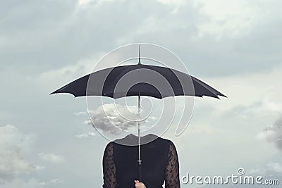 Small cloud that repairs from the rain under the umbrella of a headless woman Stock Photo