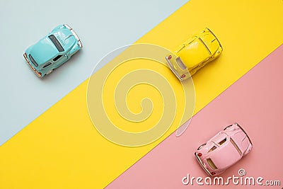 Small color toy cars on a yellow, pink and blue background. Business competition, winners and losers. Finish line Stock Photo