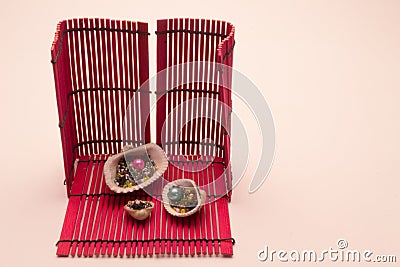 Small colored sewing decor on a red wicker wooden stand in shells. Stock Photo