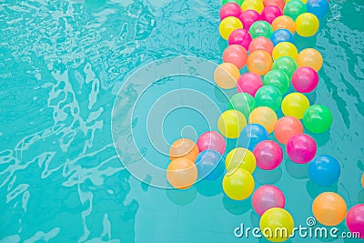 Small colorful beach balls floating in swimming pool abstract concept for pool party s. Stock Photo