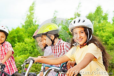 Small cute girl in helmet holds bike handle-bar Stock Photo