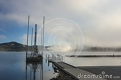 Small dock and barge by lake. Stock Photo