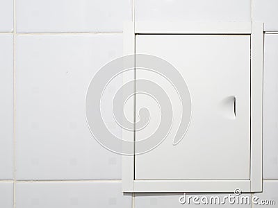 Small door in the bathroom with pipes inside Stock Photo