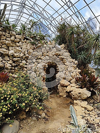 small door to an artificial cave in the greenhouse cactus garden Stock Photo