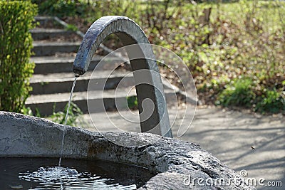 A small drinking well of stone and metal, a source of drinking water accessible for free in public place Stock Photo