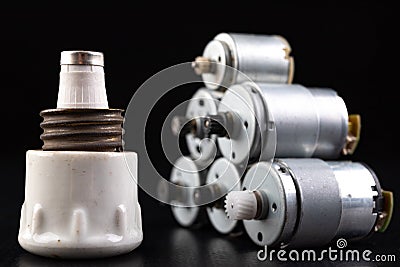 Small electric motor and ceramic fuse. Electrical accessories in the mechanic's workshop Stock Photo