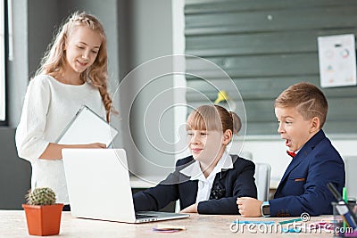 A small employee helps to work for small businessmen at the table Stock Photo