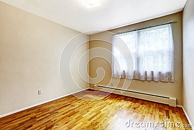 Small empty basement room with hardwood floor and beige walls Stock Photo