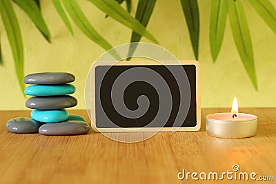 Small empty slate in width to write a message posed on the bamboo floor with gray and blue stones columns in the lifestyle Zen wit Stock Photo