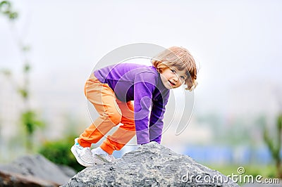 A small fair-haired girl in a purple sweater Stock Photo